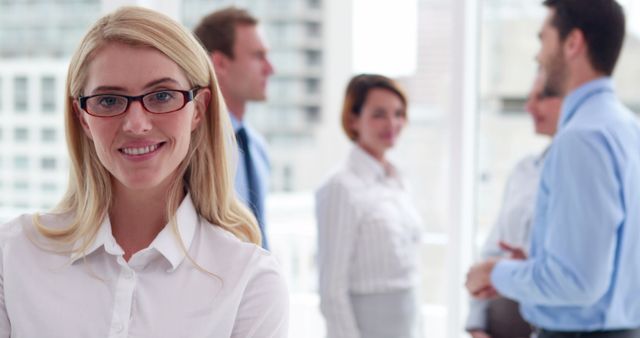 Confident Businesswoman Smiling with Colleagues in Office Background - Download Free Stock Images Pikwizard.com