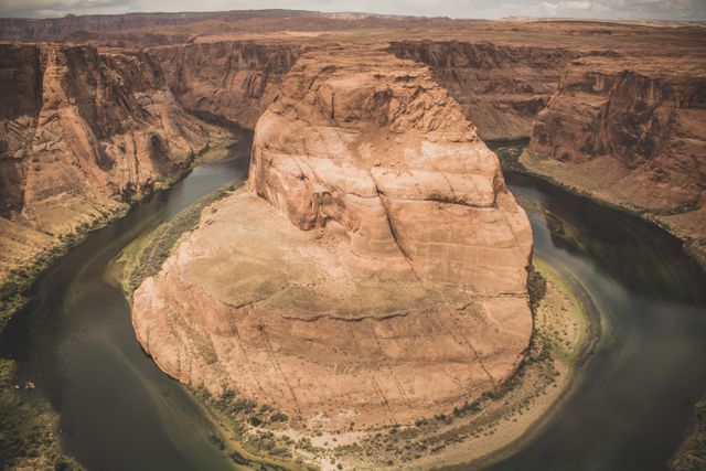 This striking view showcases Horseshoe Bend in Arizona, featuring the curved path of the Colorado River around the prominent rock formation. Ideal for use in travel and tourism promotions, geological studies, outdoor adventure advertisements, or as a stunning visual for educational material on natural landmarks.