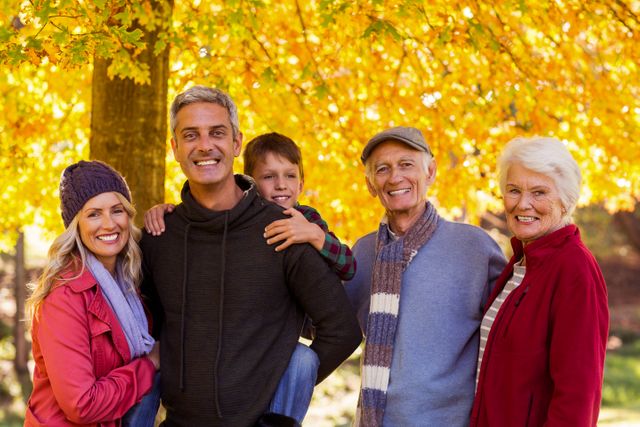 Portrait of happy multi-generation family standing at park during autumn