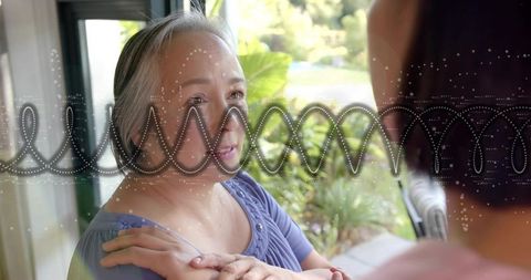 Mature Asian woman enjoying conversation through glass door with dotted waveform overlay