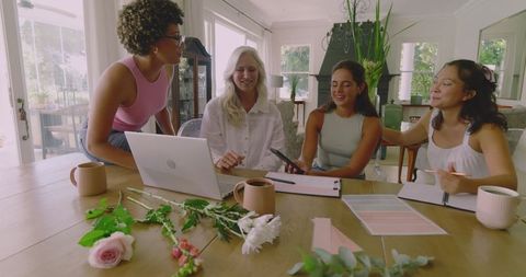 Creative Group of Women Planning Wedding with Laptop and Flowers