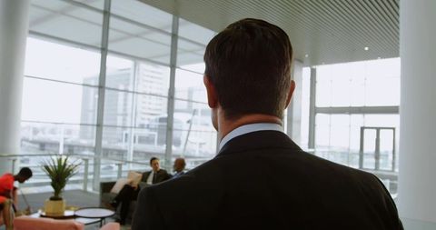 Rear View Asian Businessman in Office Lounge with Team Discussion