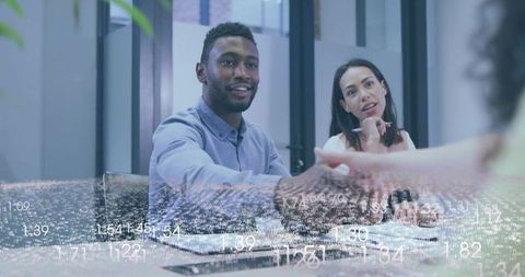 Handshake at conference table with data overlay conveying partnership and teamwork