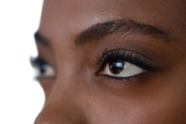 Close up of woman eyes looking away against white background