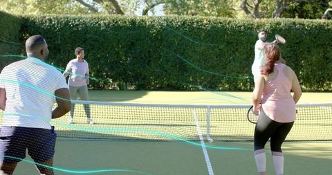 Playing mixed doubles volleying on grass tennis court during outdoor recreational match