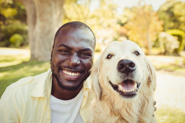 Man and golden retriever enjoying time together in park. Ideal for themes of friendship, pet care, outdoor activities, and happiness. Suitable for use in advertisements, blogs, and social media posts promoting pet products, outdoor activities, and mental well-being.