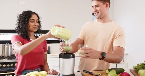 Couple Making Green Smoothie in Modern Kitchen