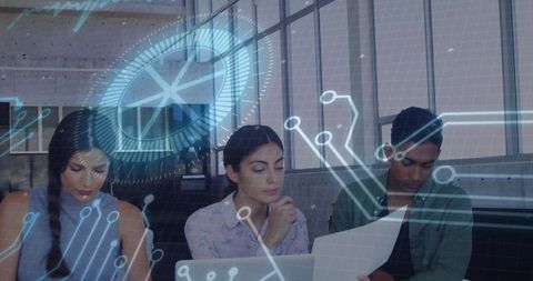 Team analyzing augmented reality data on laptop and printout in modern corporate workspace