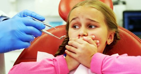 Scared young patient during dental check-up in clinic