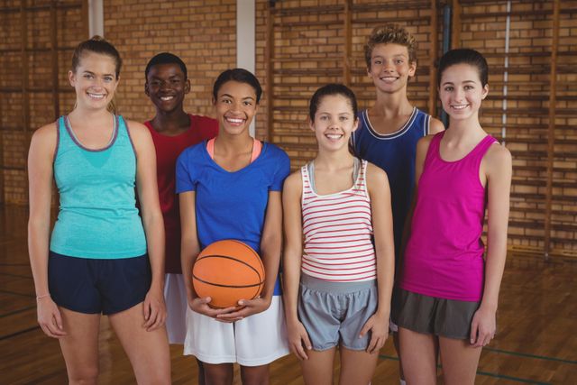 Portrait of smiling high school team standing in the basketball court
