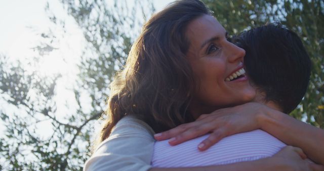 Joyful Embrace Between Two Women in Sunlit Outdoor Setting - Download Free Stock Images Pikwizard.com