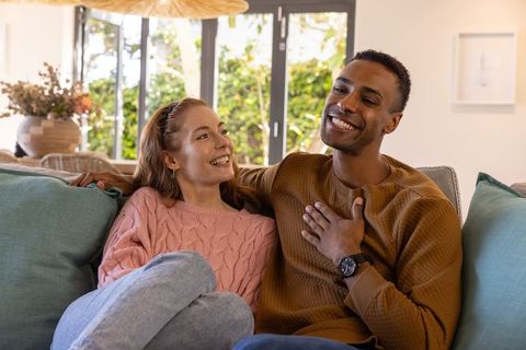 Smiling Couple Relaxing on Sofa at Home , Cozy Interior