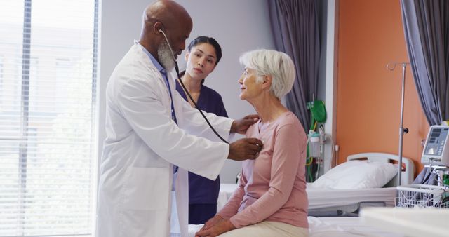 Senior woman sitting on hospital bed while doctor uses stethoscope. Nurse stands watching. Useful for topics related to healthcare services, elderly care, medical examinations, hospital experiences, and patient care.