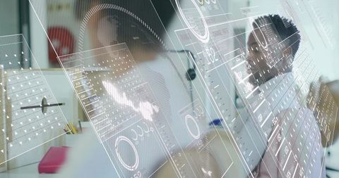 Midadult tech professionals analyzing holographic ui dashboards collaborating in office