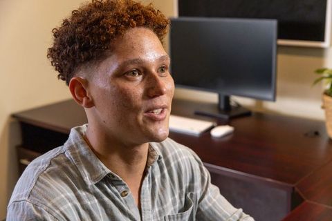 Male Office Worker Speaking at Desk in Cozy Workspace