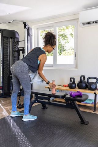 Woman Hydrating in Home Gym During Workout