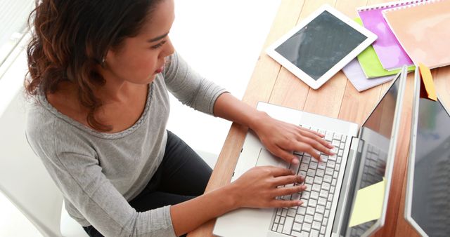 Young woman working on laptop at home desk - Download Free Stock Images Pikwizard.com