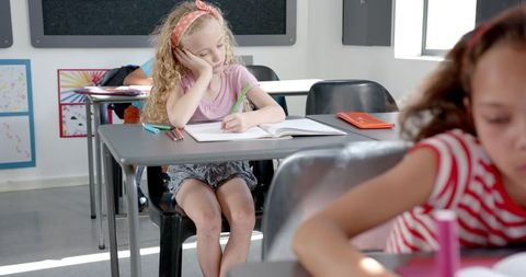 Pensive student writing classroom