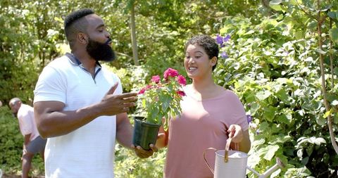 Friends Gardening Together in Lush Garden with Vibrant Blossoms