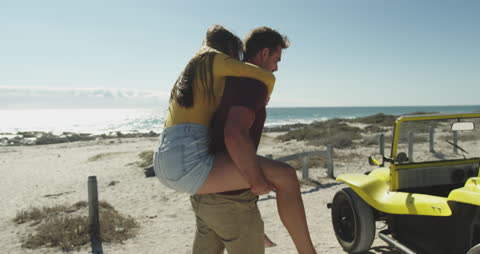 Couple Enjoying Summer Beach Adventure by Seaside Buggy