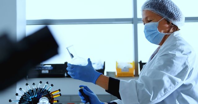 Scientist in Laboratory Coat Conducting Experiment with Test Flask - Download Free Stock Images Pikwizard.com