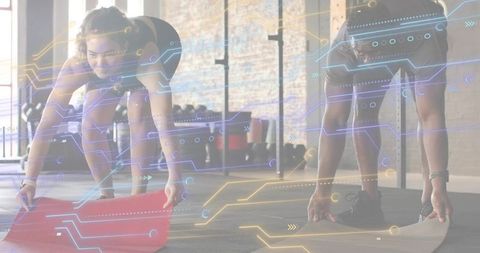 Man and woman unrolling exercise mats with digital tech overlay in industrial gym studio