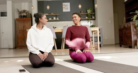 Women enjoy relaxing yoga session in home interior