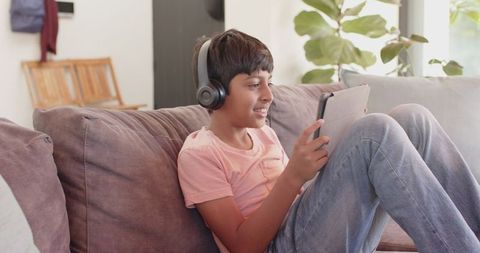 Child Enjoying Tablet with Wireless Headphones in Comfortable Home Setting