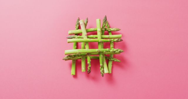 Image of fresh asparagus over pink background. fusion food, fresh vegetables and healthy eating concept.