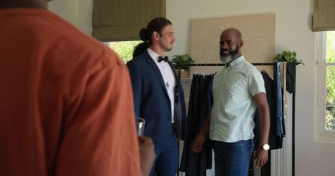 Groom in elegant attire celebrates with friends before wedding
