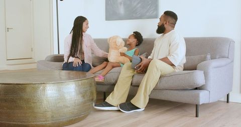 Family Bonding Time on Sofa with Tablet and Teddy Bear