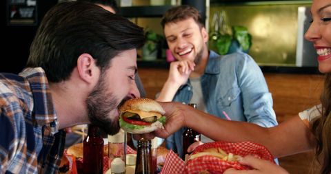 Friends Enjoying Laughter and Burgers at Casual Dining - Download Free Stock Images Pikwizard.com