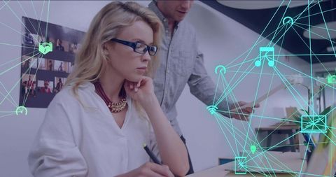 Coworking team collaborating on digital design with tablet and network overlay