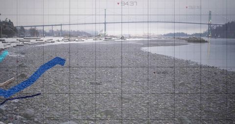 Pebble beach stretching toward suspension bridge with grid and data overlay, coastal analytics