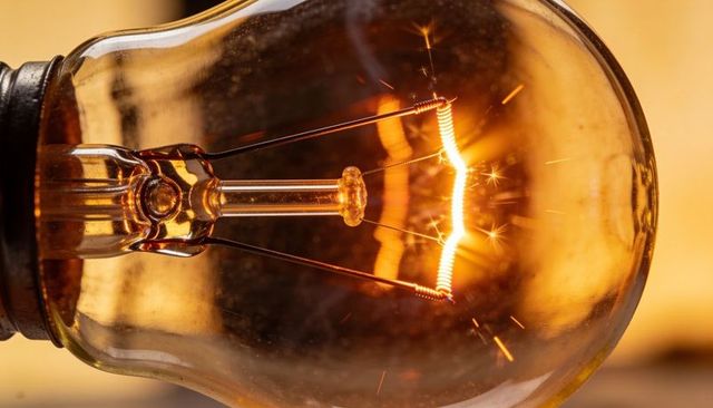 Macro glowing incandescent filament sparking closeup warm amber illumination