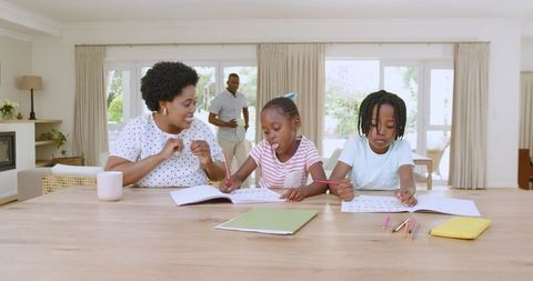 Mother Assisting Children with Homework in Vibrant Home Environment