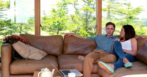 Young Couple Relaxing on Couch in Bright Home Living Room