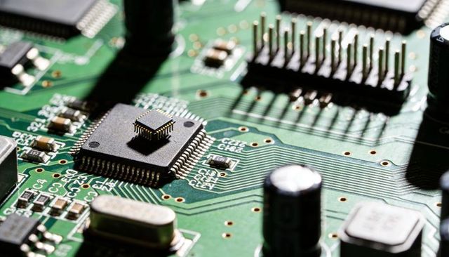 Microchip with tiny bare die mounted on smd ic on green printed circuit board macro