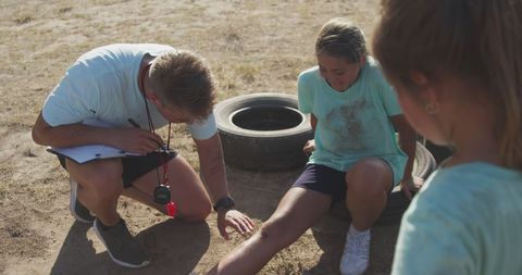 Coach Assisting Injured Child Outdoors