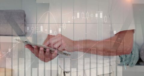 Businessman Analyzing Financial Data on Tablet with Digital Graphics Overlay