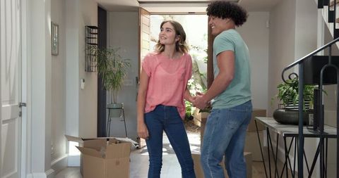 Young couple embracing in new home during moving day
