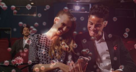 Couple with smartphone in theater amid viral cells representation