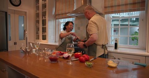 Senior asian couple cooking together with joyful companionship