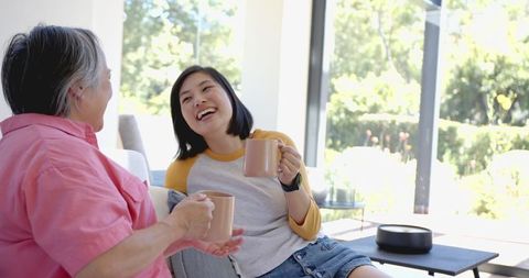 Smiling Women Enjoying Coffee in Bright Living Room