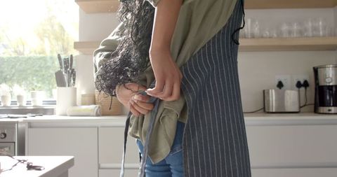Woman Preparing for Cooking in Bright Modern Kitchen