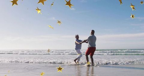 Joyful Couple Dancing on Beach with Celebratory Gold Stars