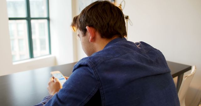 Young Man Using Smartphone in Modern Office Space - Download Free Stock Images Pikwizard.com