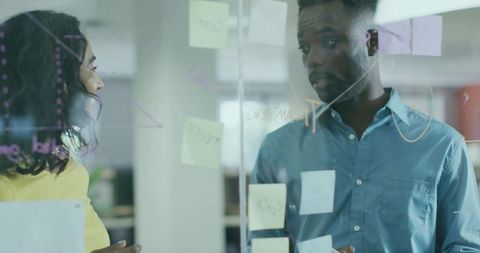 Professional Colleagues Discussing Ideas at Office Glass Board