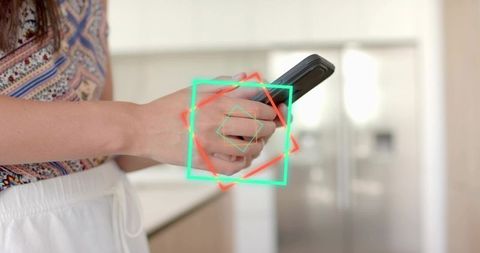 Young woman holding smartphone in modern kitchen with neon geometric overlay