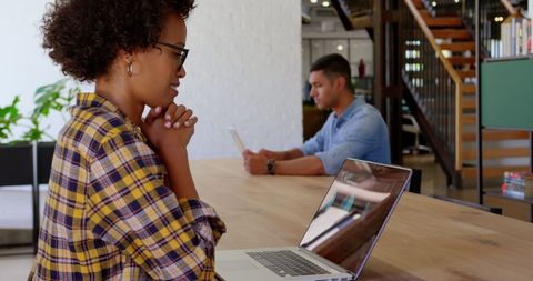 Focused Businesswoman Working on Laptop in Modern Office Workspace
